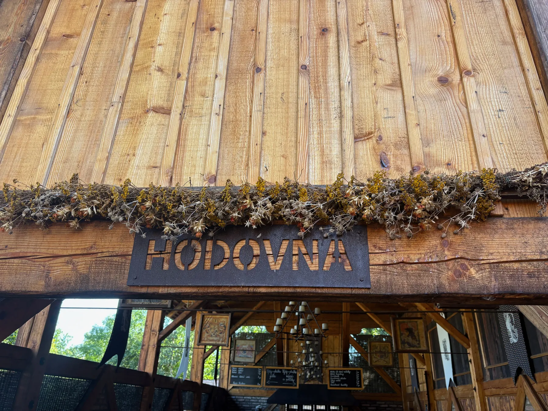 Cedule 'HODOVNA' nad dřevěným vstupem