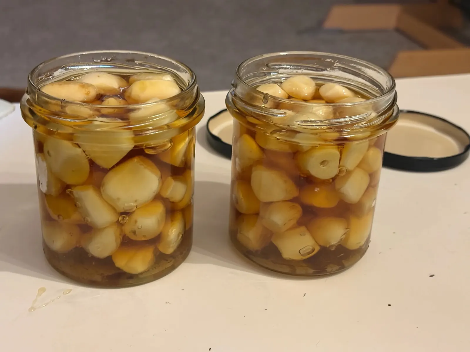 Sklenice s česnekem právě zalévaná medem, med teče pomalu shora