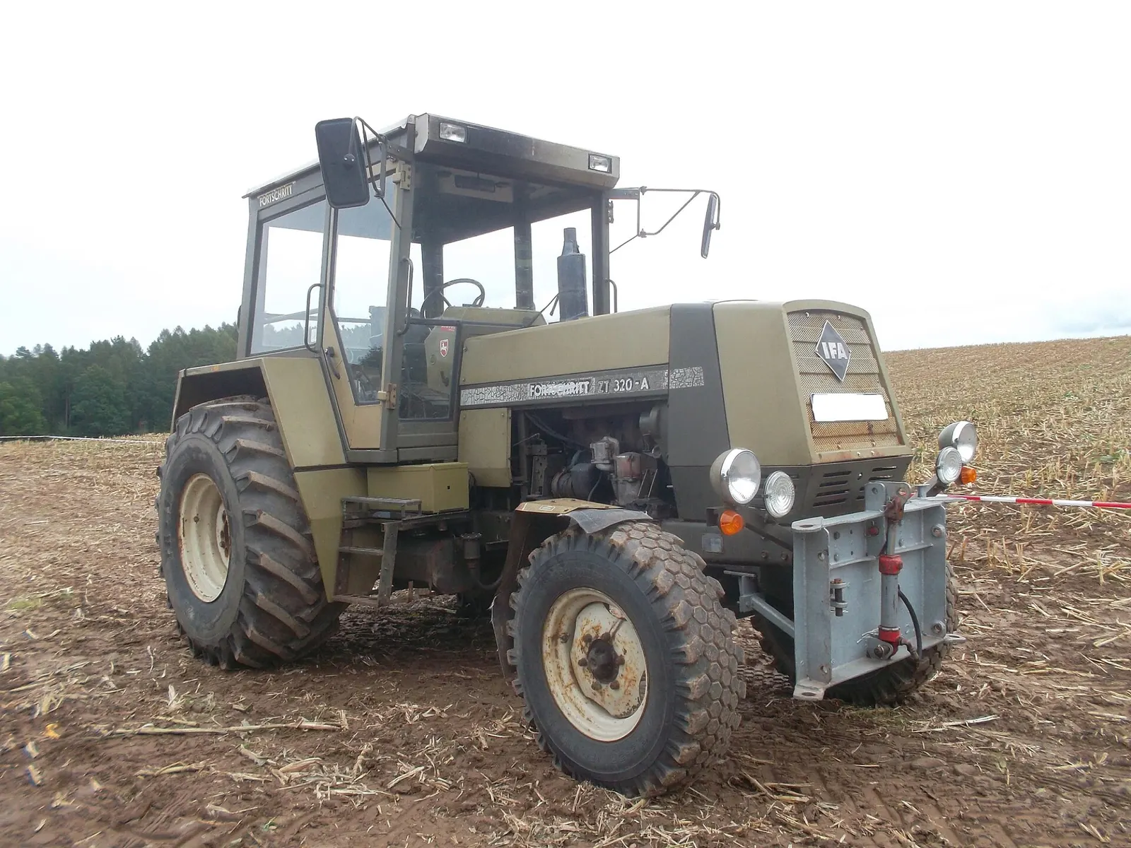 Modrý traktor Fortschritt ZT 320-A na louce