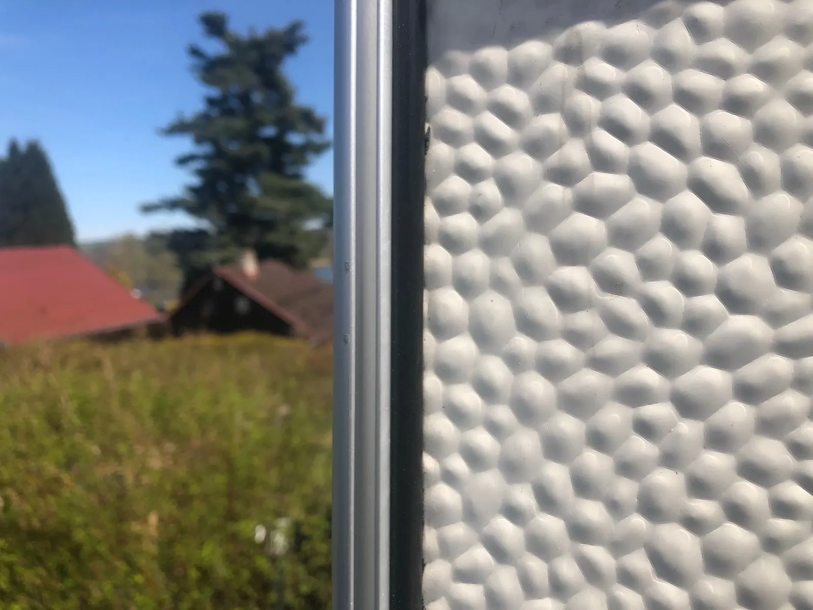 Makro detail spáry mezi dvěma panely - hliníkový profil, hexagonální textura panelu