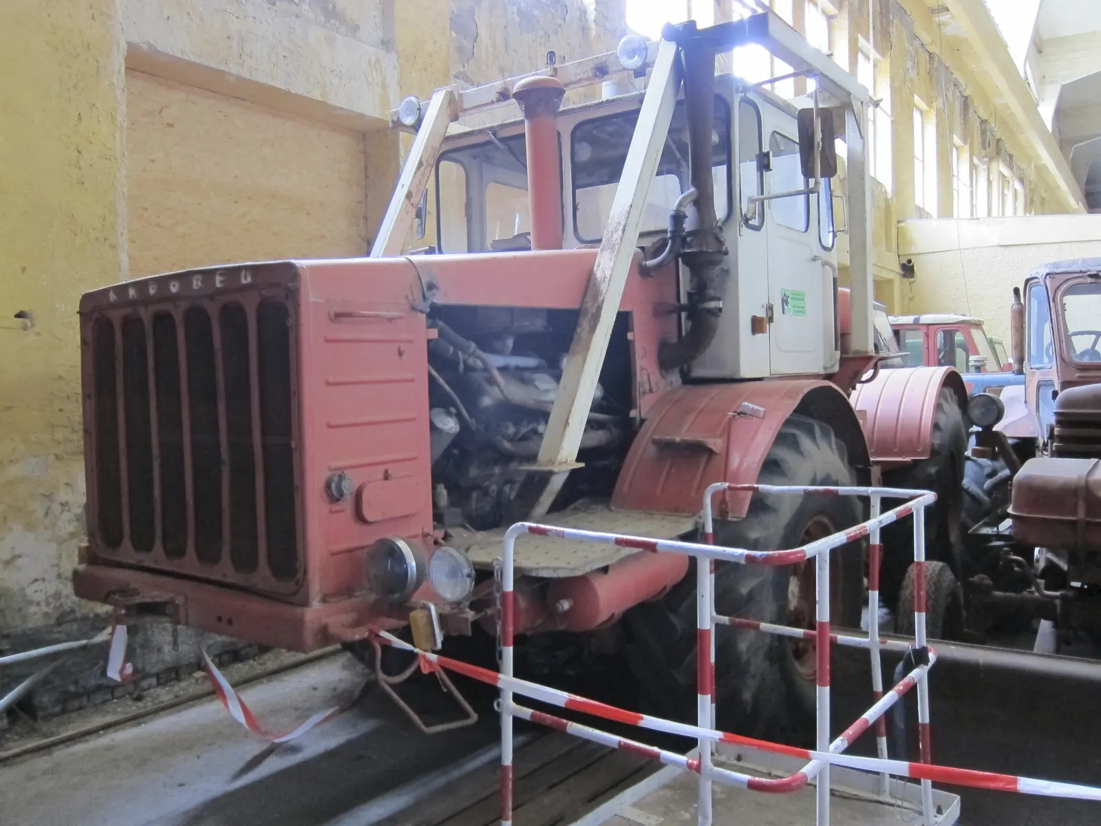 Červený K-700 s otevřenou kapotou v muzejní hale