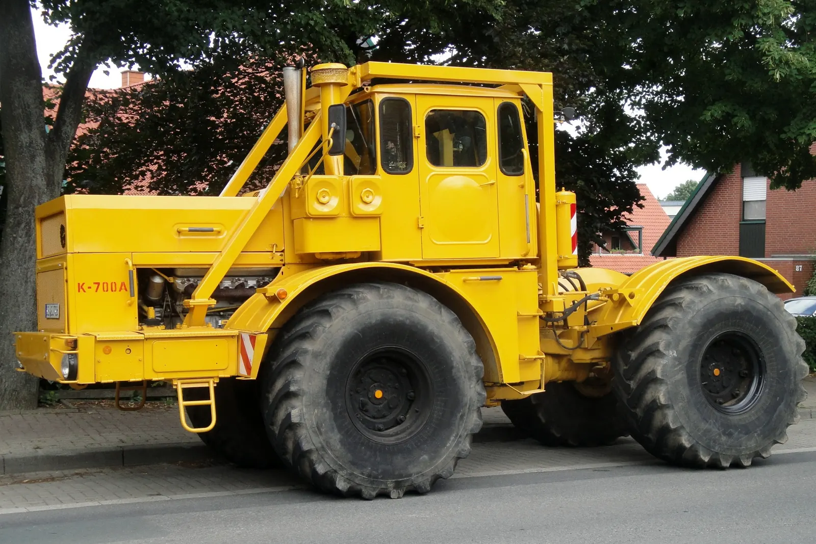 Žlutý traktor Kirovec K-700A z boku, s nápisem K-700A na kapotě