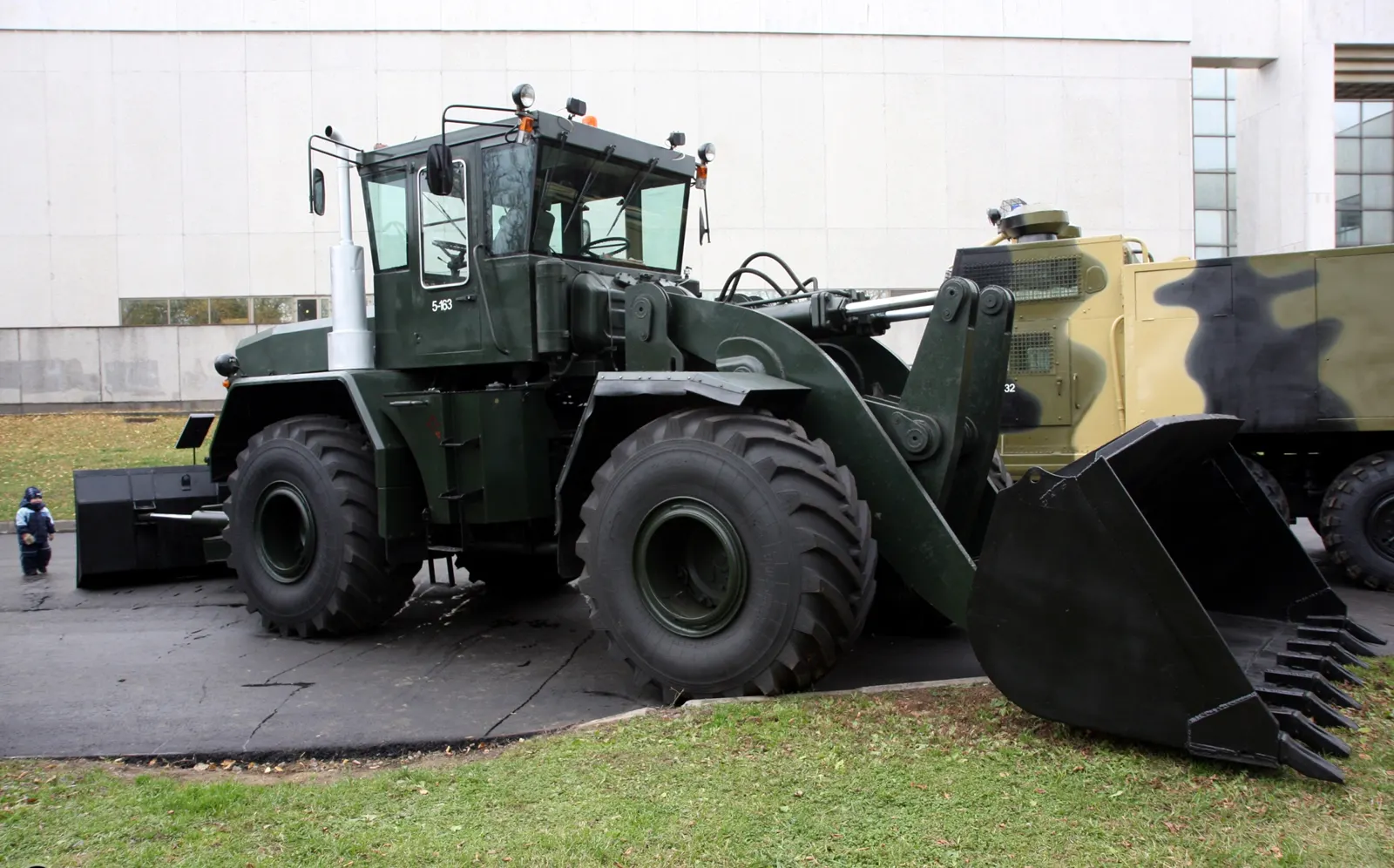 Tmavě zelený stroj K-702 s velkou čelní lopatou