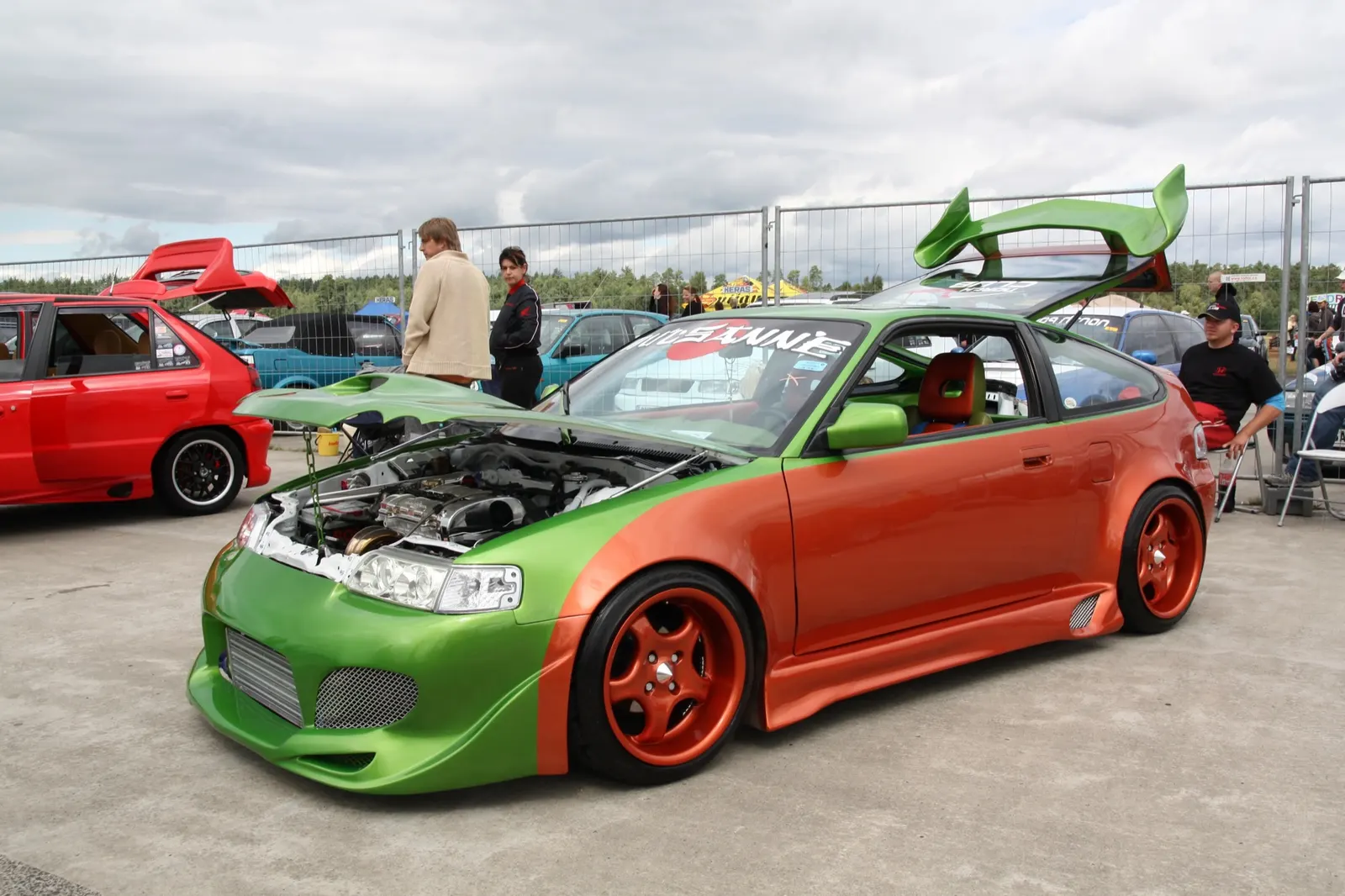 Zeleno-oranžová Honda CRX s tuning stavbou stojí v klubovém depu na letišti