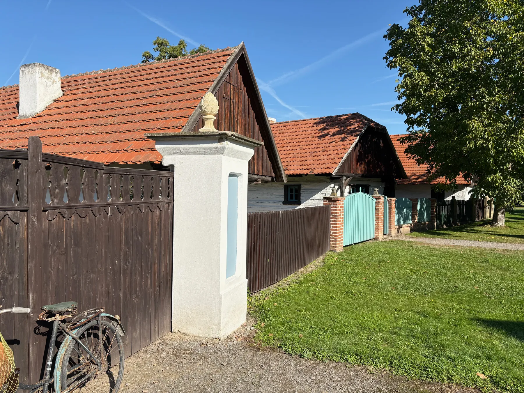 Panské zděné brány s bílou omítkou a světlebéžovým sloupem