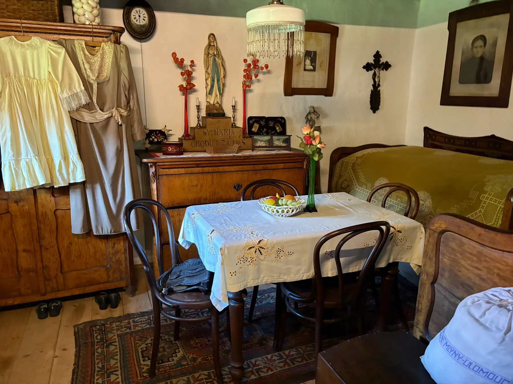 Sváteční světnice s figurinami, prostřený stůl a svaté obrazy
