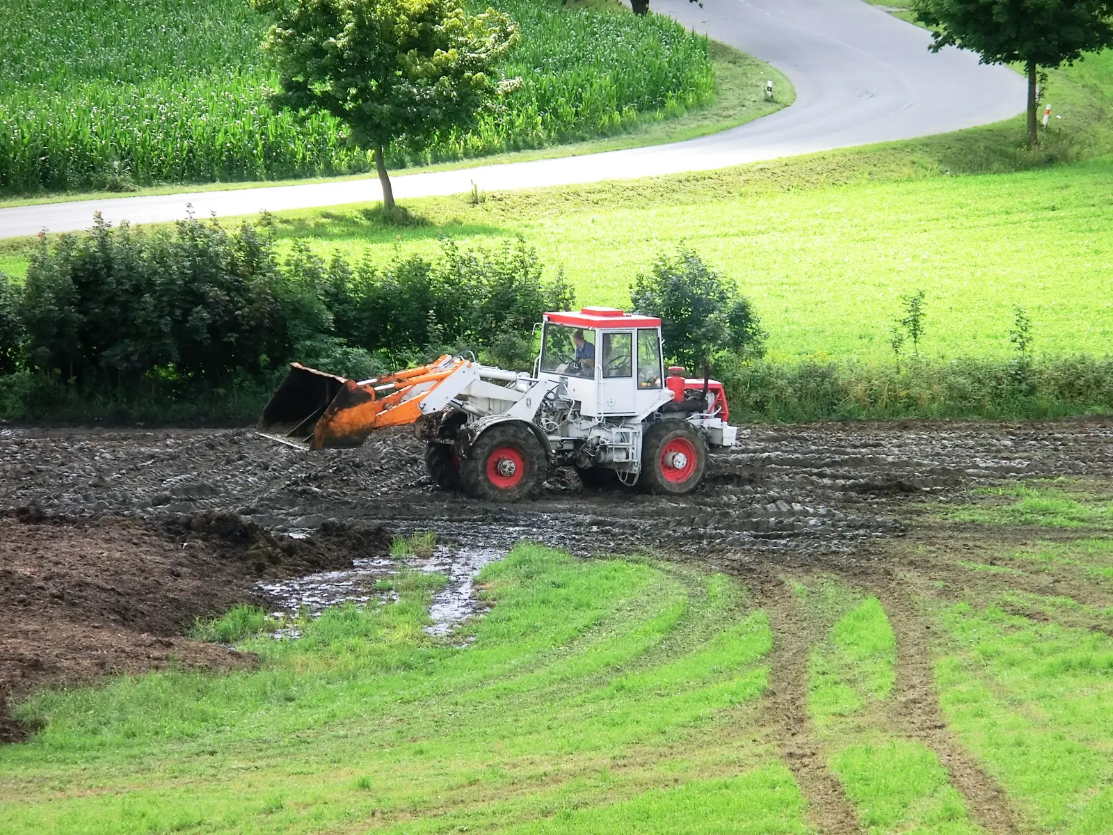 ŠT 180 N s nakladačem rovná hnůj na rozbláceném poli