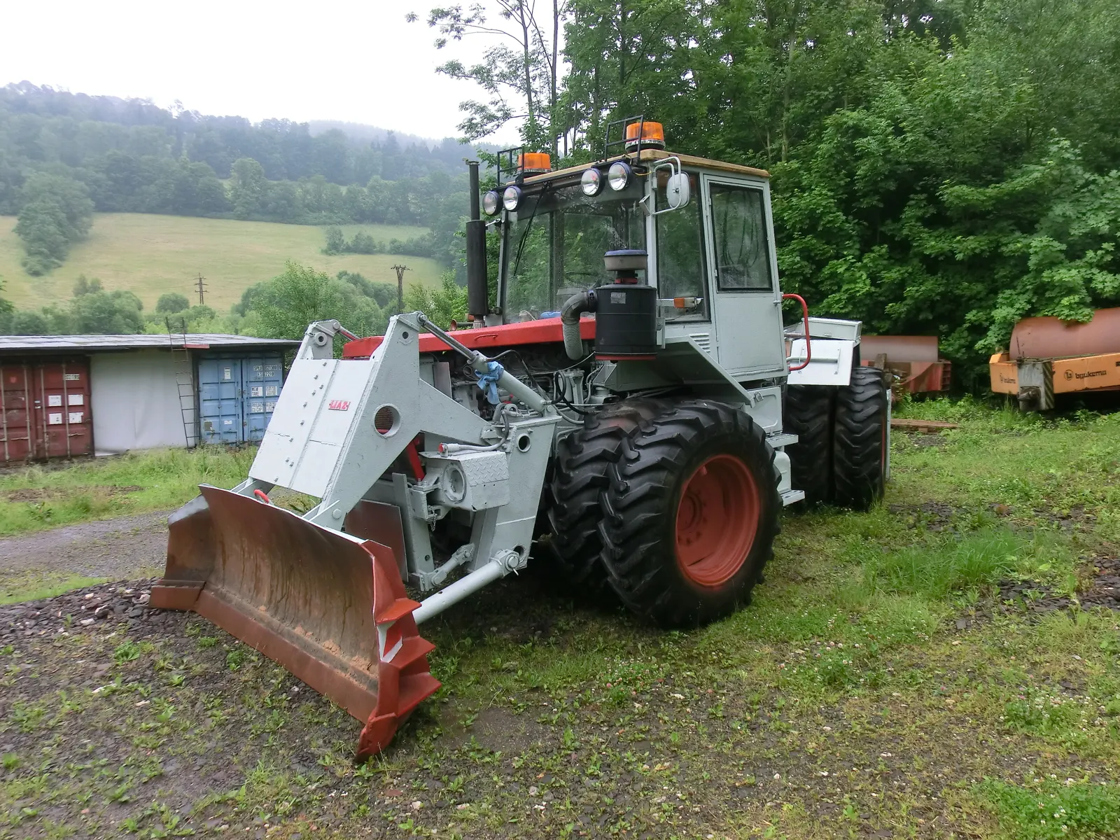 Šedý ŠT 180 N s radlicí a dvojmontáží kol s červenými disky