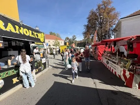 Alej stánků s trdelníky a jídlem, procházející lidé