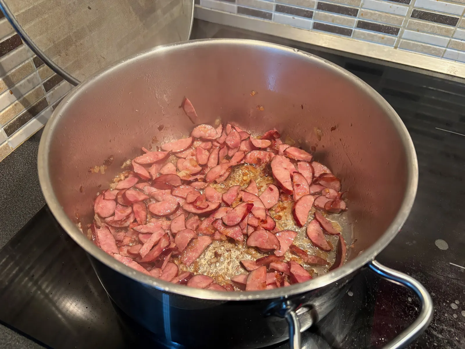 Klobása s cibulí mírně zasmažené, klobása má hnědé kraje